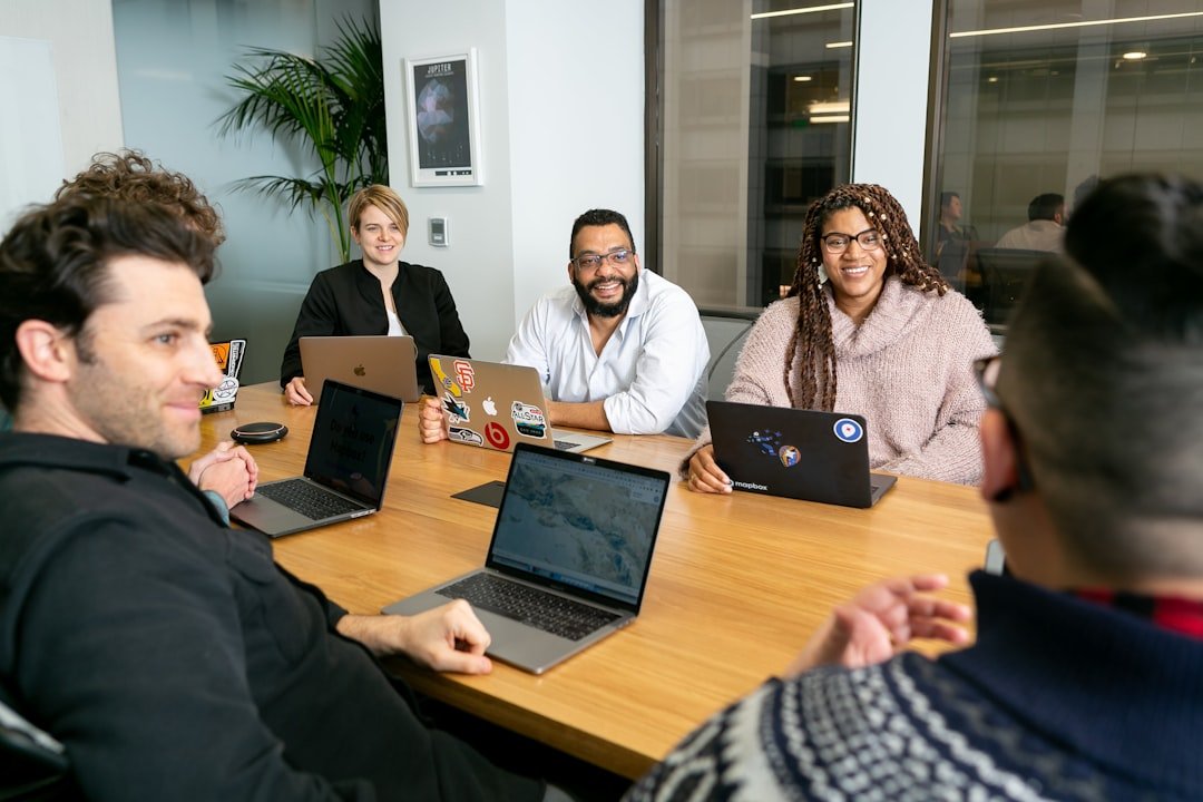 Team discussing digital marketing campaign around a laptop